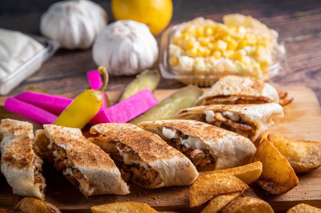 Authentic Middle Eastern shawarma platter with vibrant sides and crispy potatoes.